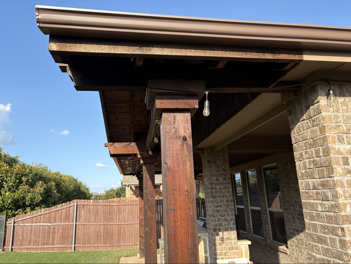 Finished stained patio cover with posts and beams in Heath TX backyard by Terra Renovations