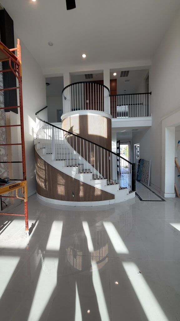 Curved staircase with wood slat accent wall by Terra Renovations, Dallas-Fort Worth general contractor