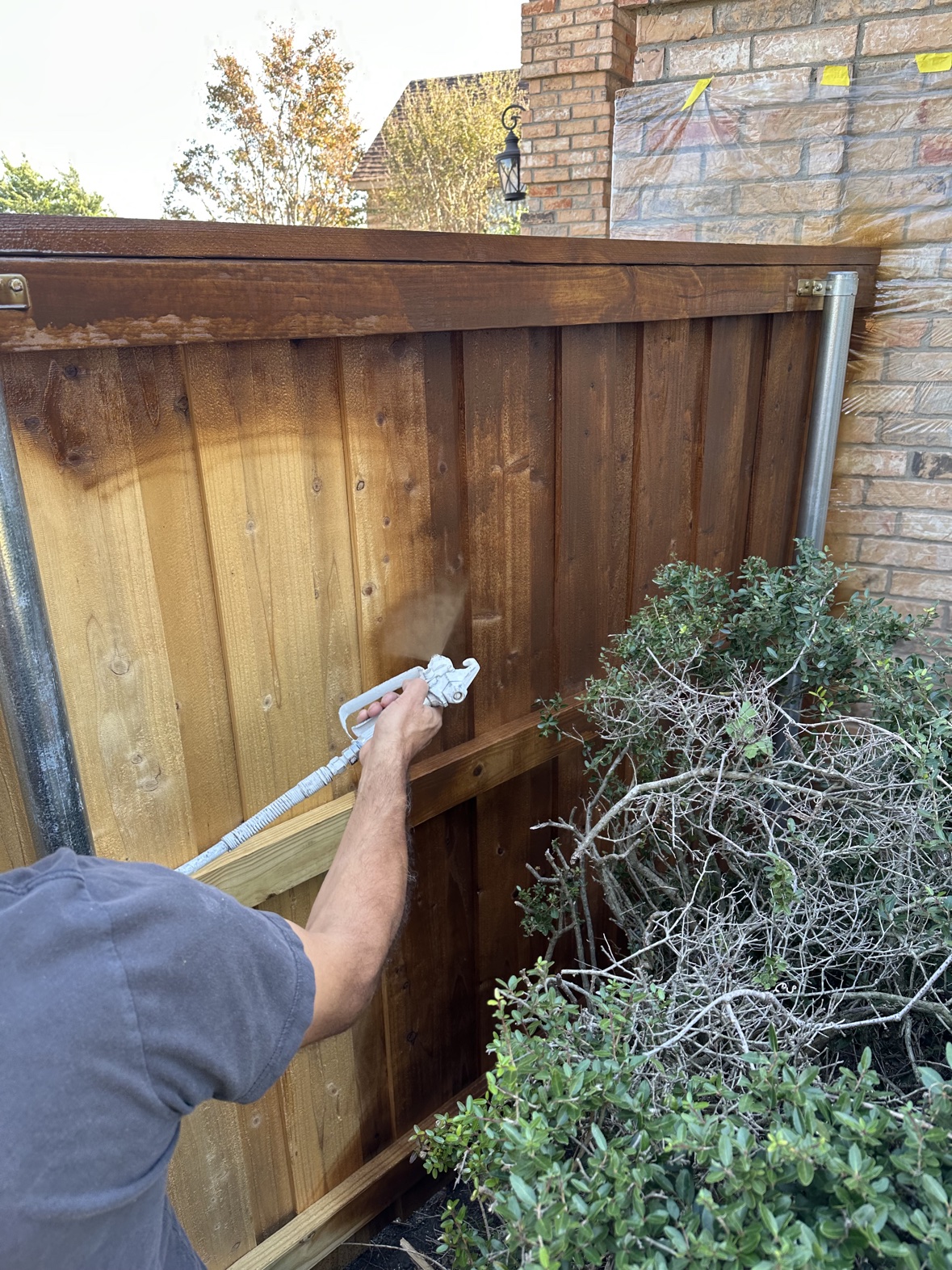 Spraying fence stain for even coverage in Dallas Fort Worth