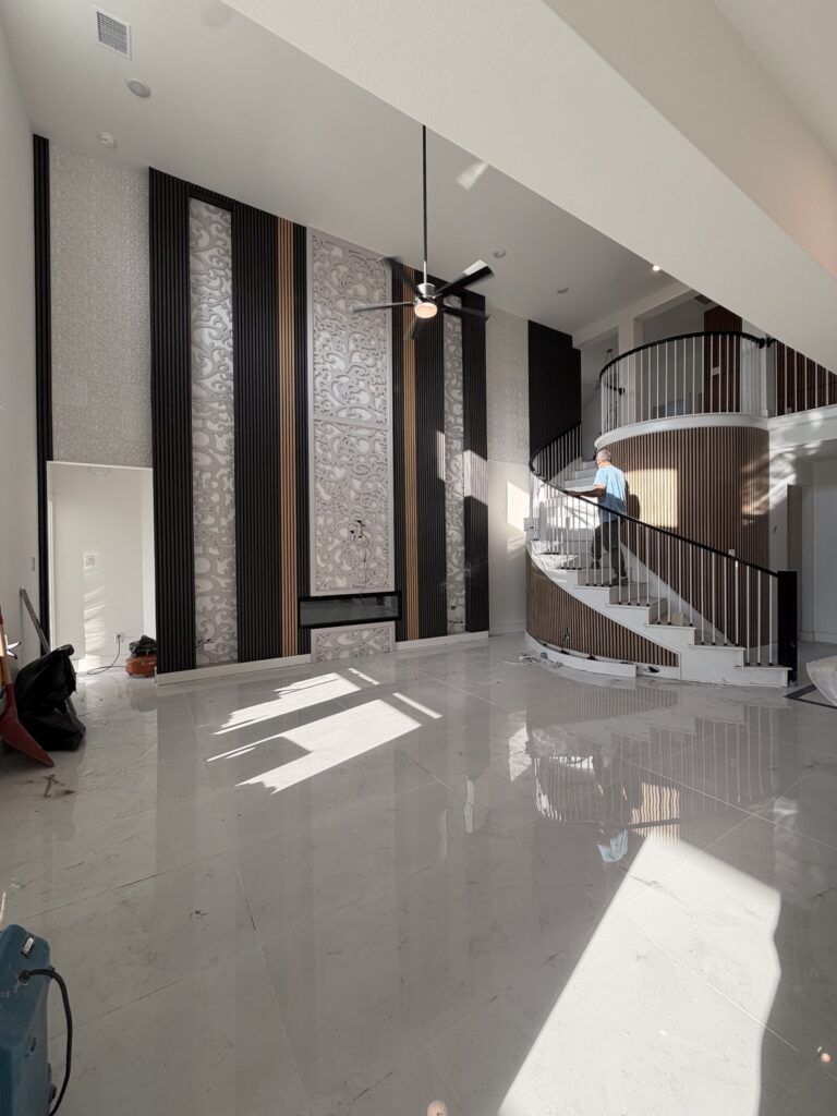 Two-story accent wall with slat panels beside a curved staircase, accent wall contractor in Dallas TX
