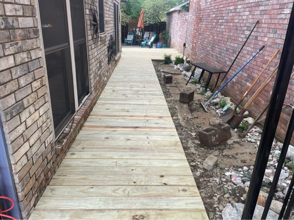 Long new wood deck walkway built alongside a brick home by deck builders in Dallas TX