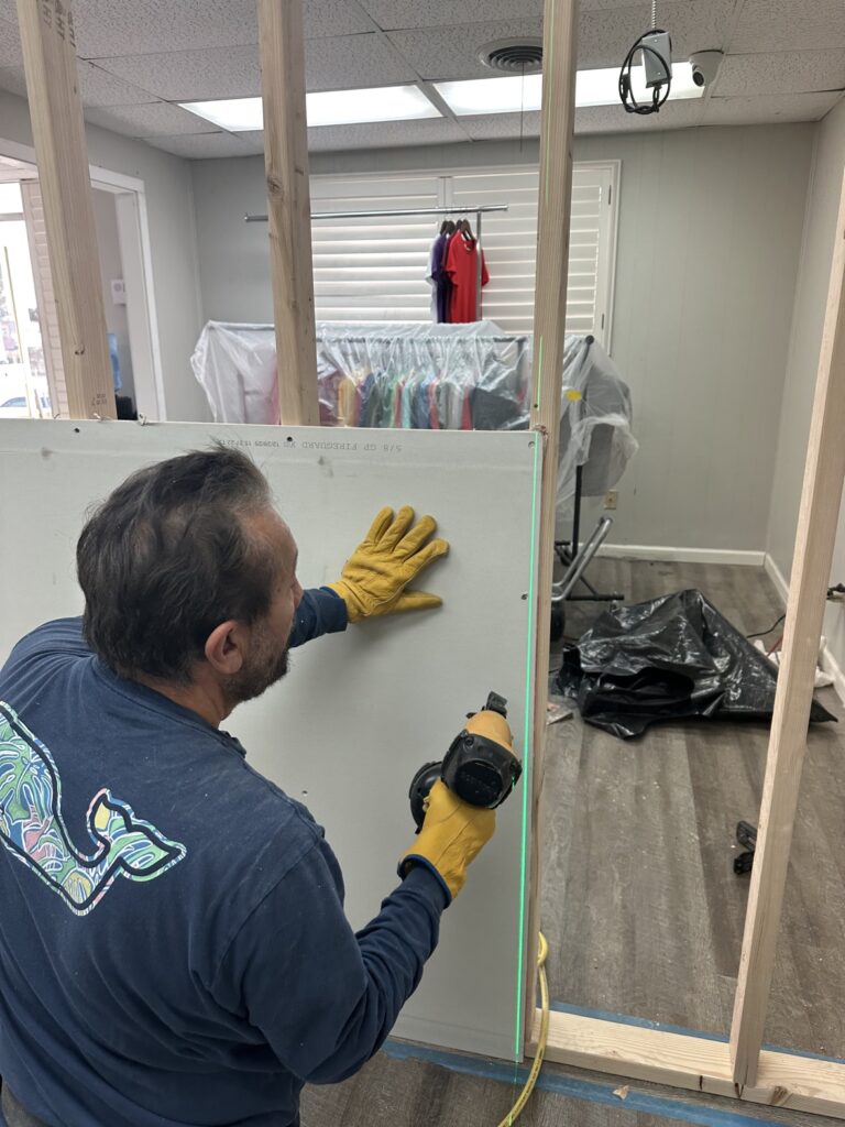 Drywall hanging with a laser level on a partition wall, drywall installers in Fort Worth TX