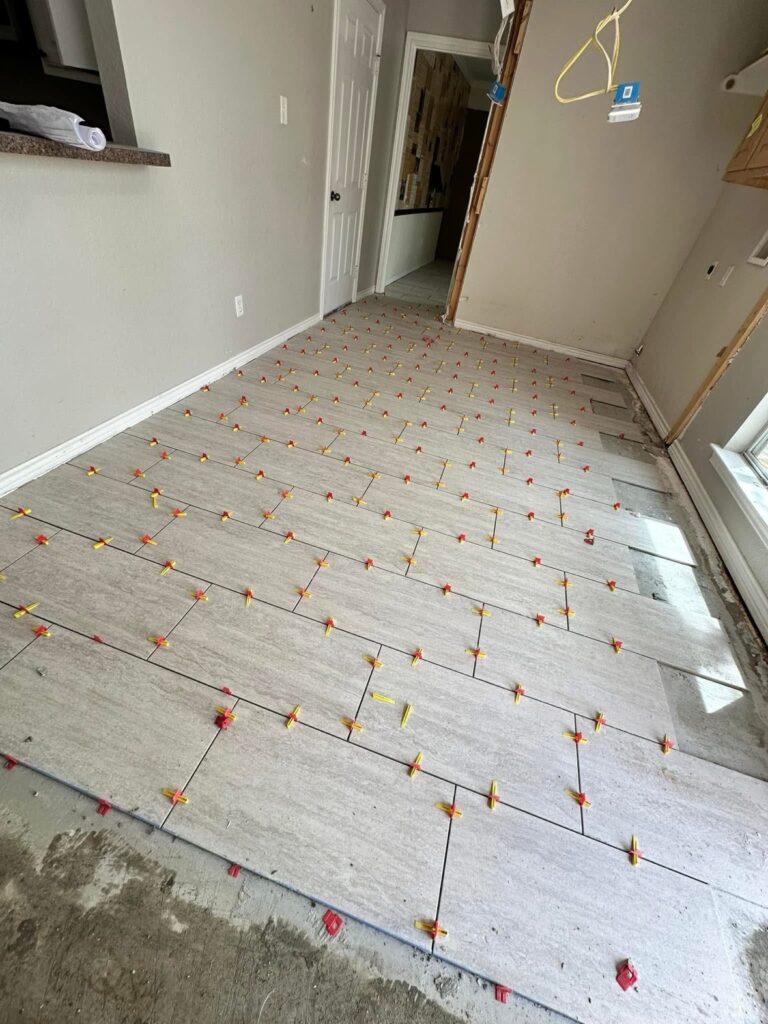 Large format tile flooring installation with leveling spacers by Terra Renovations, Dallas-Fort Worth tile contractor