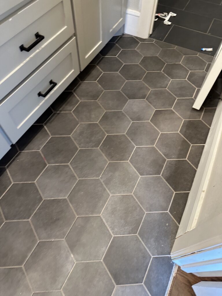 Dark hexagon tile bathroom floor installed by flooring contractors in Dallas Fort Worth TX