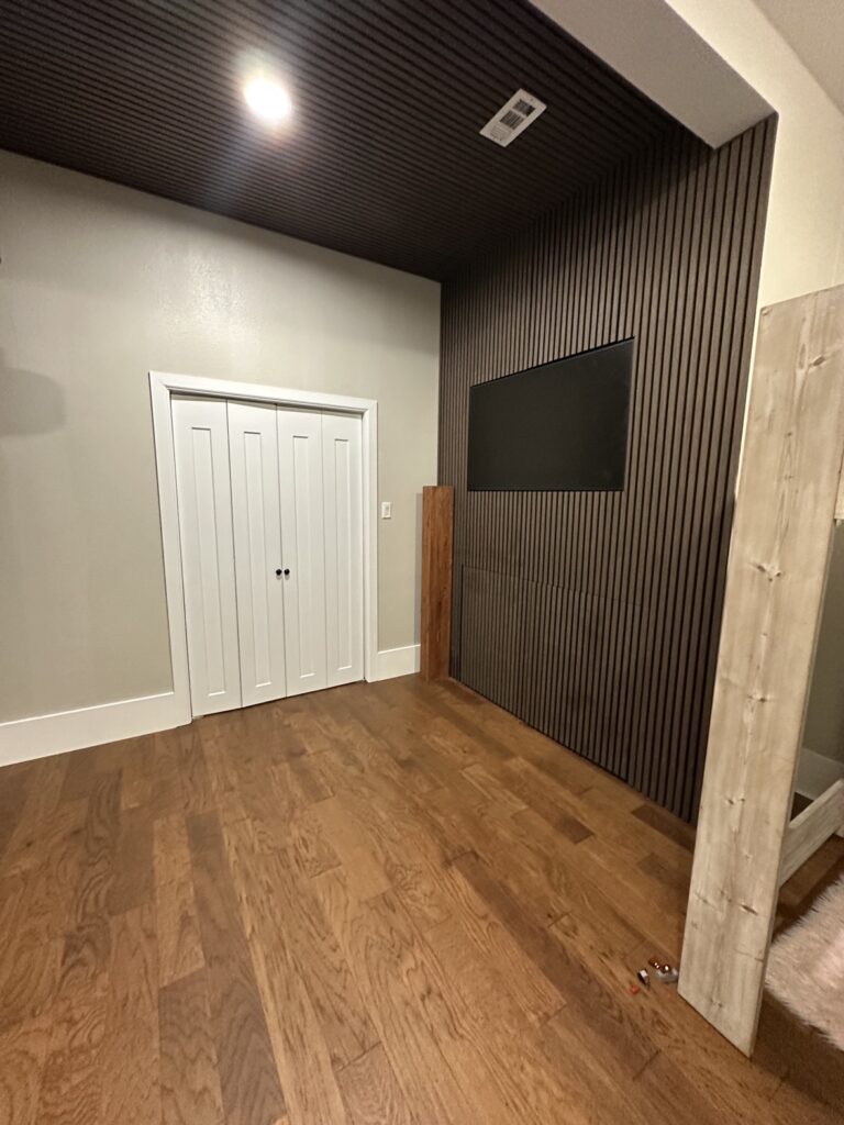 Black slat accent wall and ceiling in a media room, accent walls in Fort Worth TX